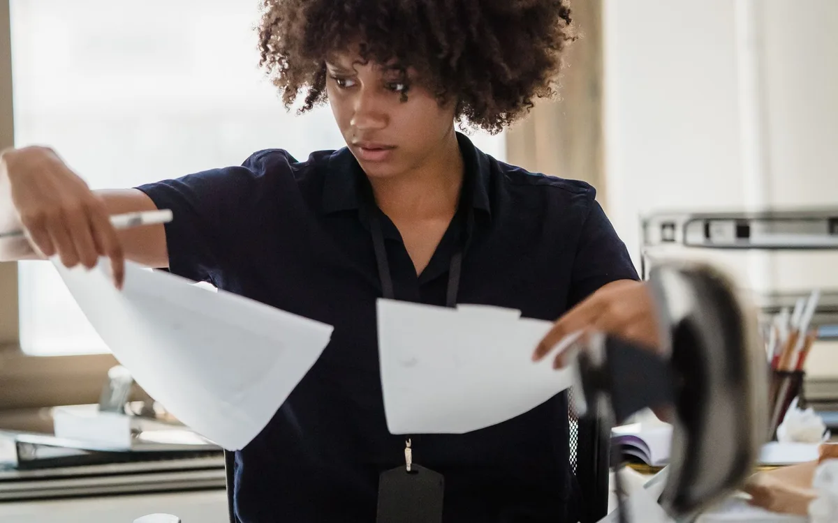 A professional comparing printed documents during a source review