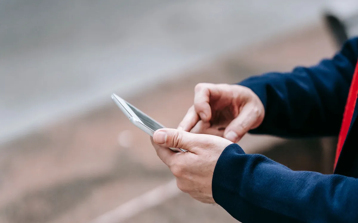 Person using a smartphone outdoors to represent a location-sensitive local search