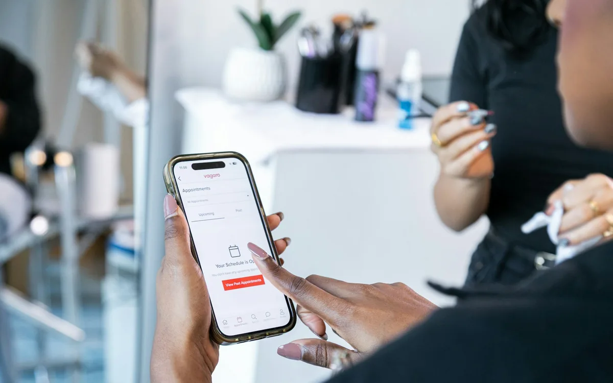 Customer using a smartphone appointment booking app inside a service business