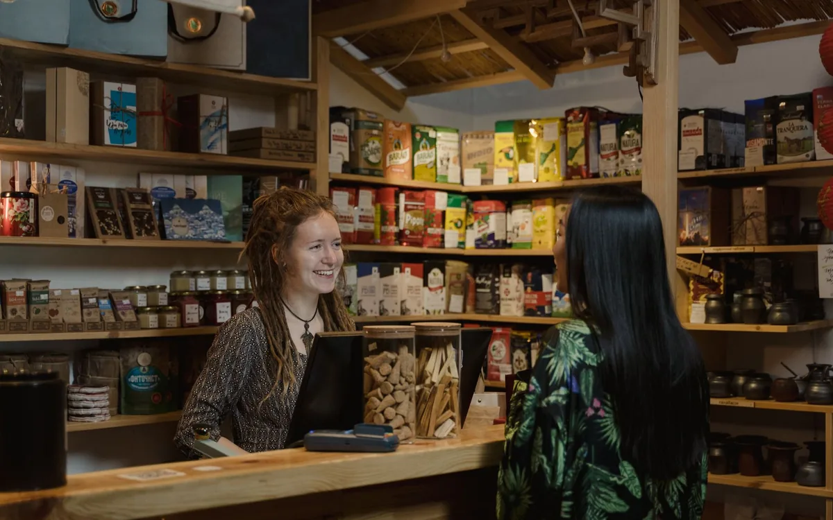Small shopkeeper speaking with a customer across a retail counter